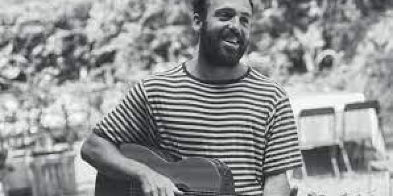 Dylan Cox in t-shirt with guitar